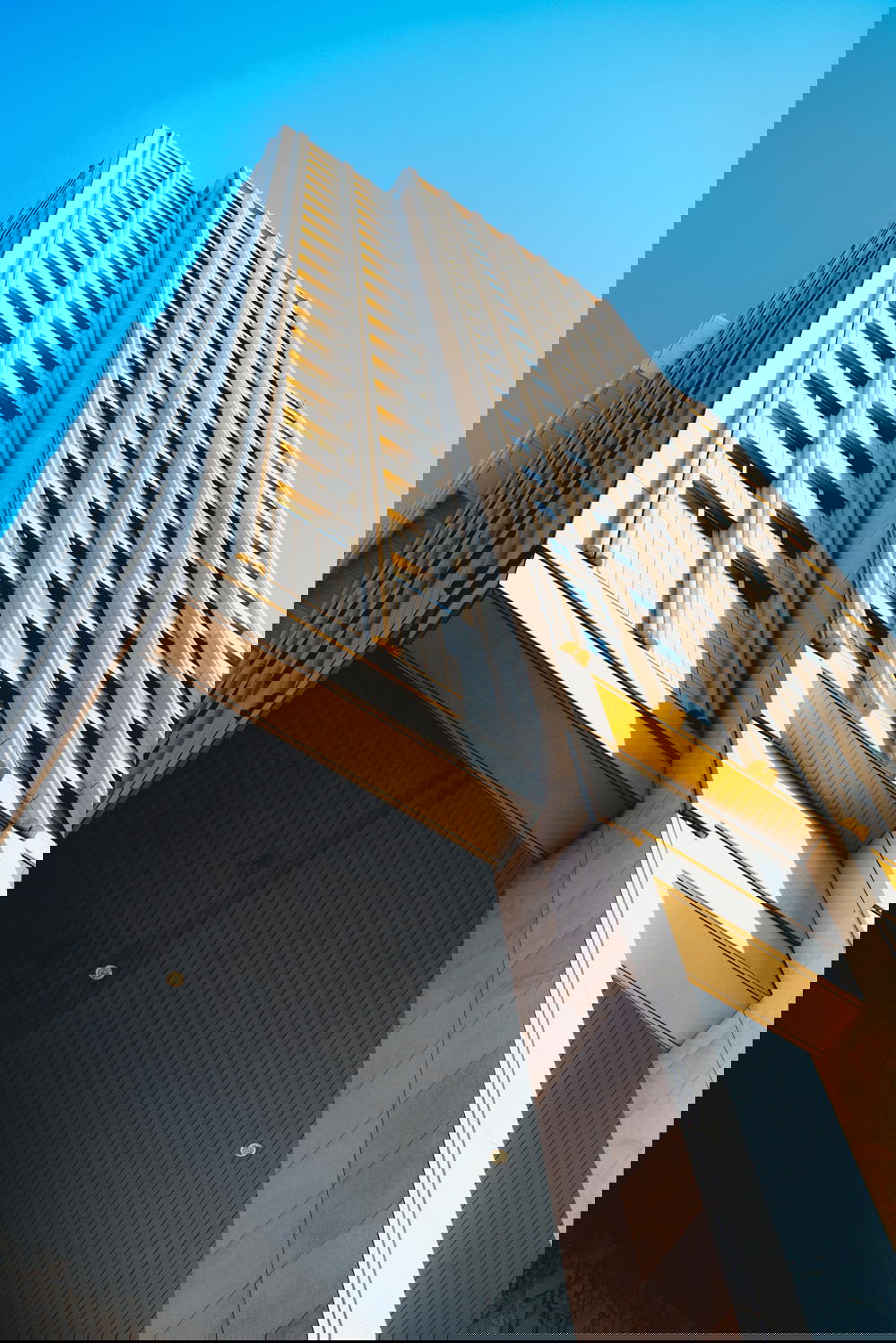 A tall architecture in Rotterdam against a blue sky.