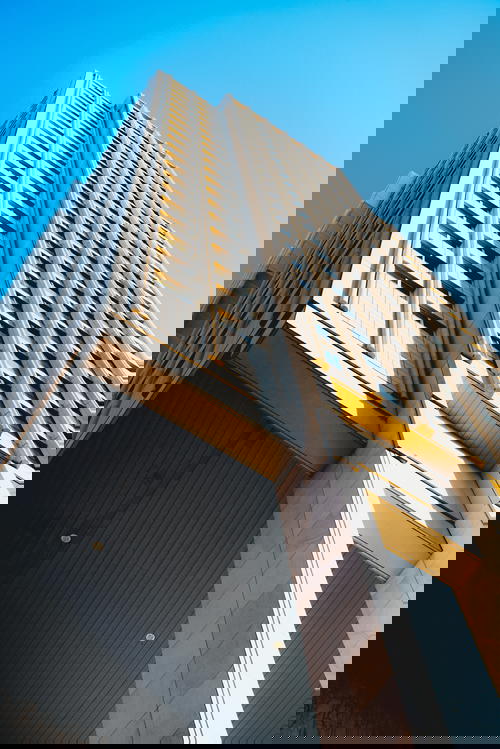 A tall architecture in Rotterdam against a blue sky.