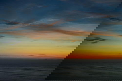 A sunset over the ocean with a boat in the background in Peru.