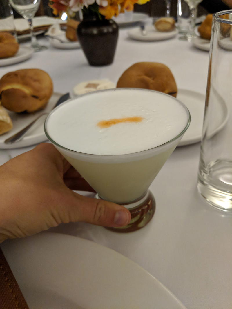 A person holding a martini at a table in Lima, Peru.