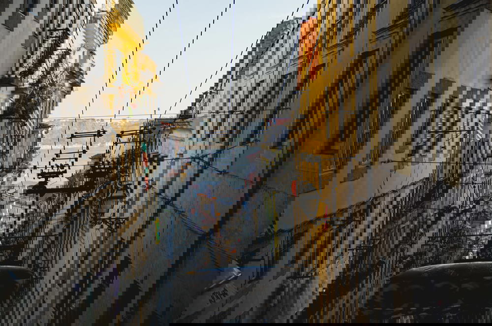 A cable car descending a narrow Lisbon street in Portugal.