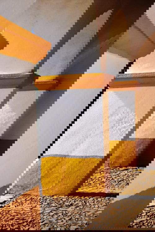 A row of white and yellow painted pillars in Portugal.