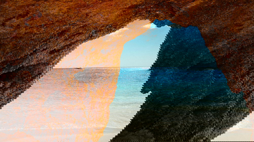 A Portugal cave with a scenic ocean view and boat.
