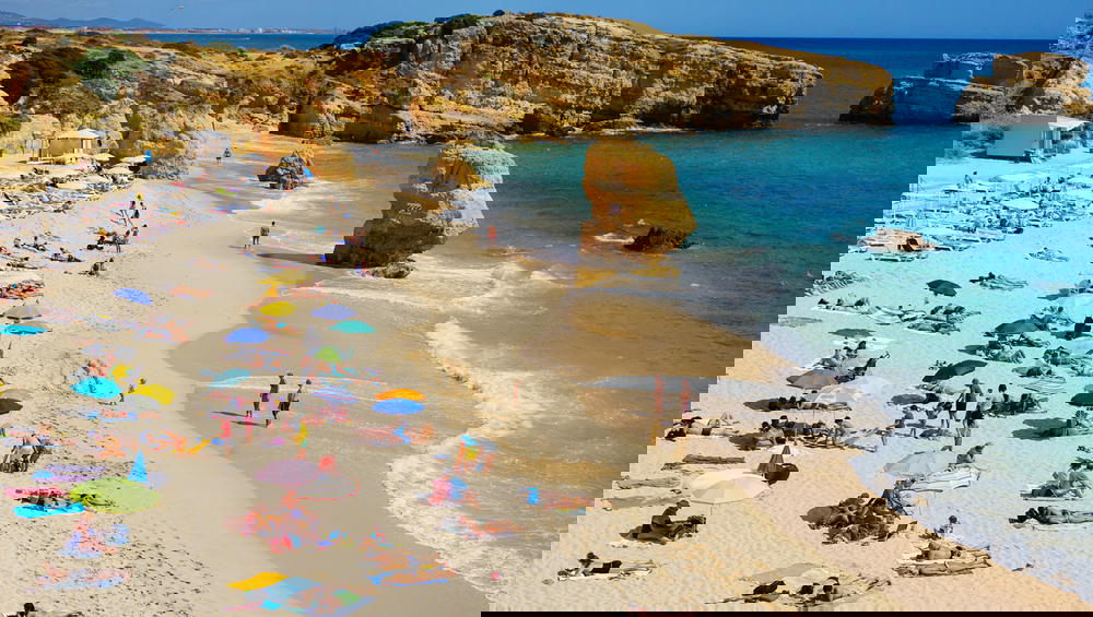 The Portugal beach is crowded with people.