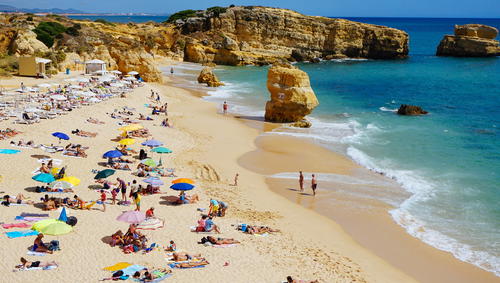 The Portugal beach is crowded with people.