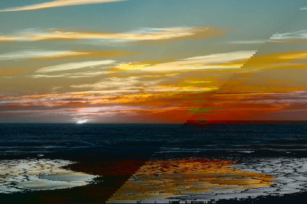 The sun is setting over a Portuguese beach.