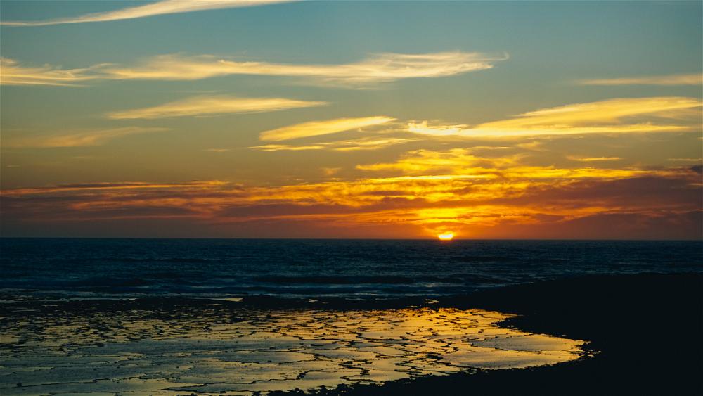 The sun is setting over a Portuguese beach.