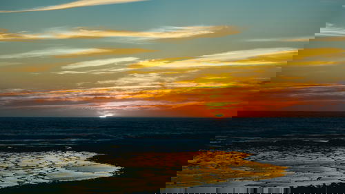 The sun is setting over a Portuguese beach.