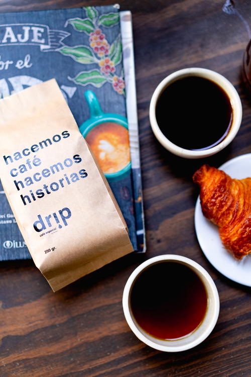 A cup of coffee and a croissant on a table.