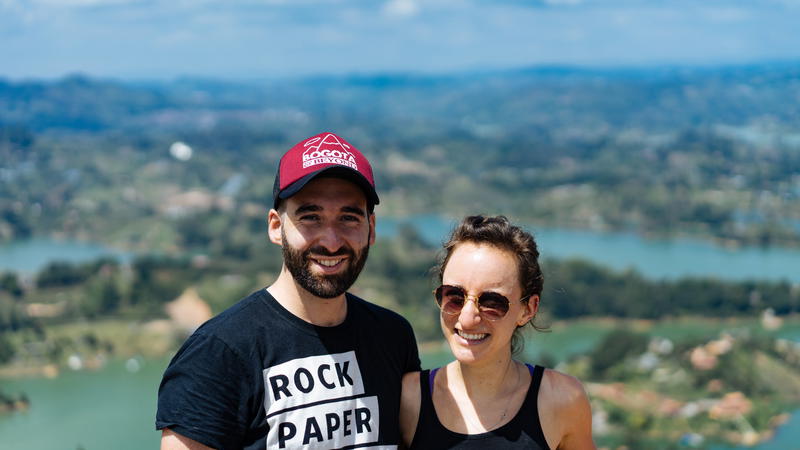 A man and woman posing for a photo on top of a mountain.