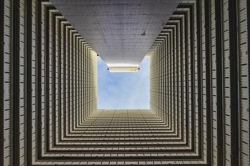 A view of the sky through a tall building.