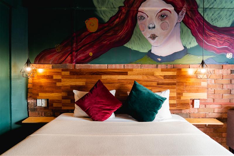 A bed in a room with a mural on the wall.