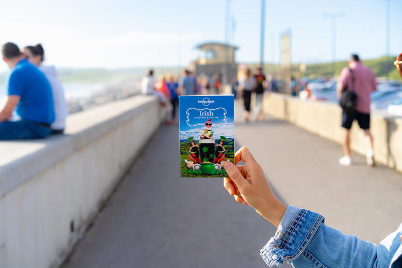 A woman holding up a card on a bridge.