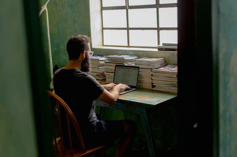 A man sitting at a desk using a laptop.