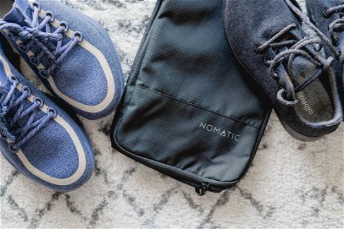Nomatic shoe bag with two pairs of shoes close by.
