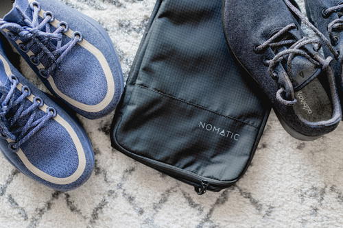 Nomatic shoe bag with two pairs of shoes close by.