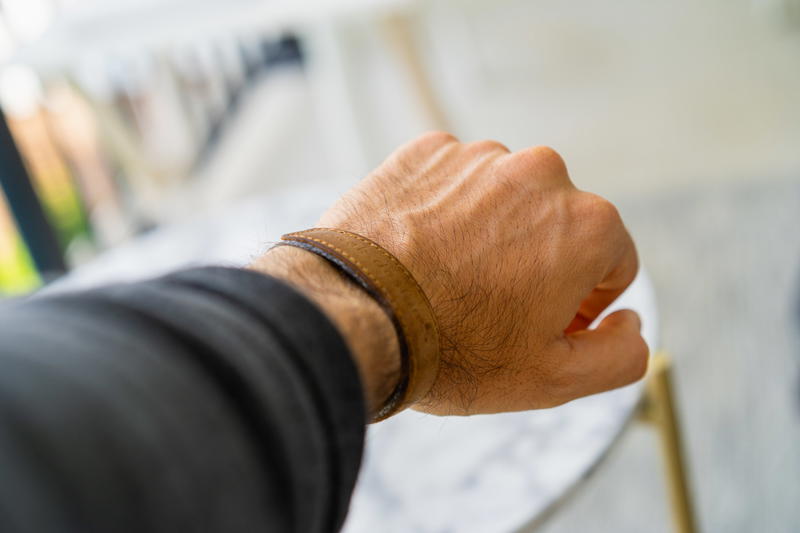 a mans hand showing a peak design wrist camera strap