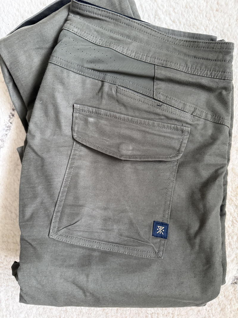 a pair of grey pants on a white carpet