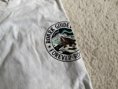 a white t-shirt with the back side of the roark logo on it