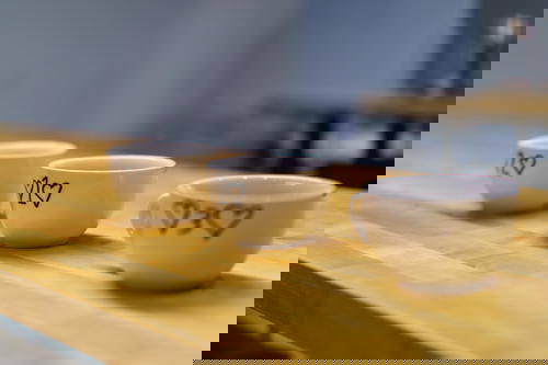 Three coffee cups on a wooden table.