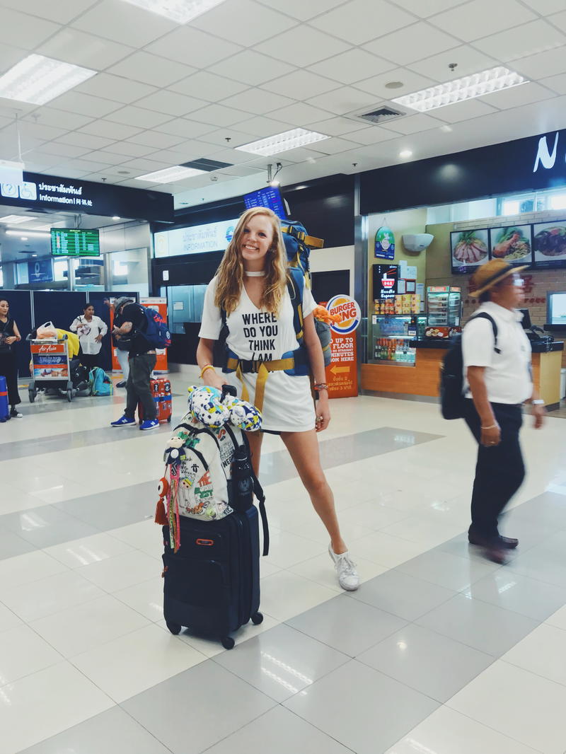 A woman with luggage in an airport.