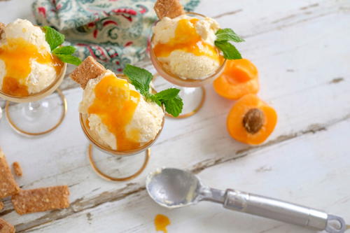 three glasses filled with ice cream and topped with peaches