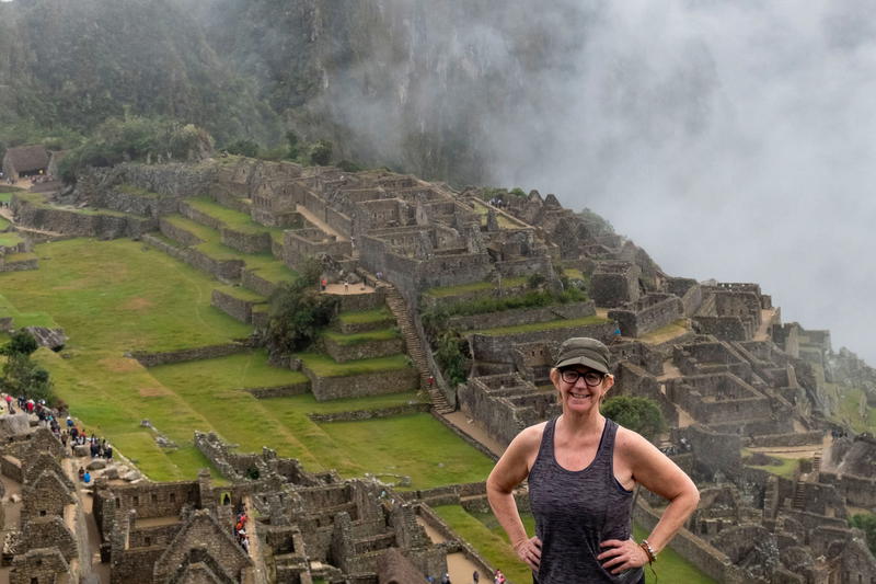 a woman standing on the edge of a mountain