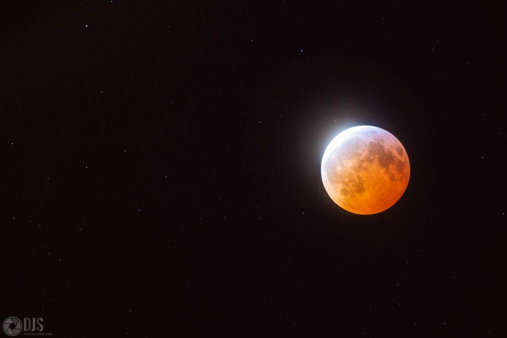 A blood moon is seen in the sky.