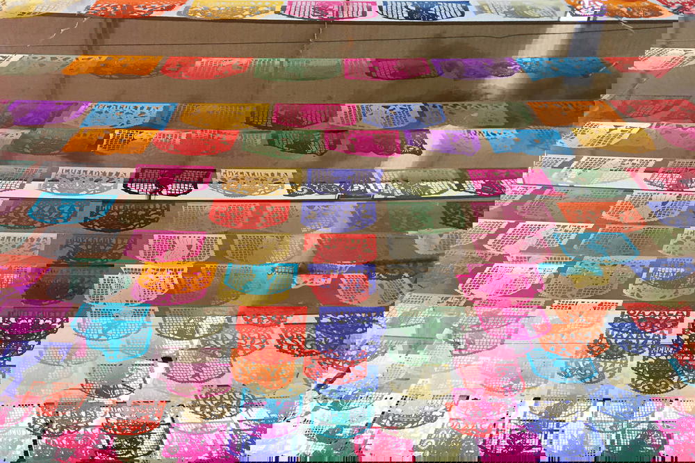 A display of colorful paper lanterns hanging from a window.