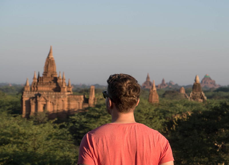 A man looking out over a temple in bagan, myanmar.