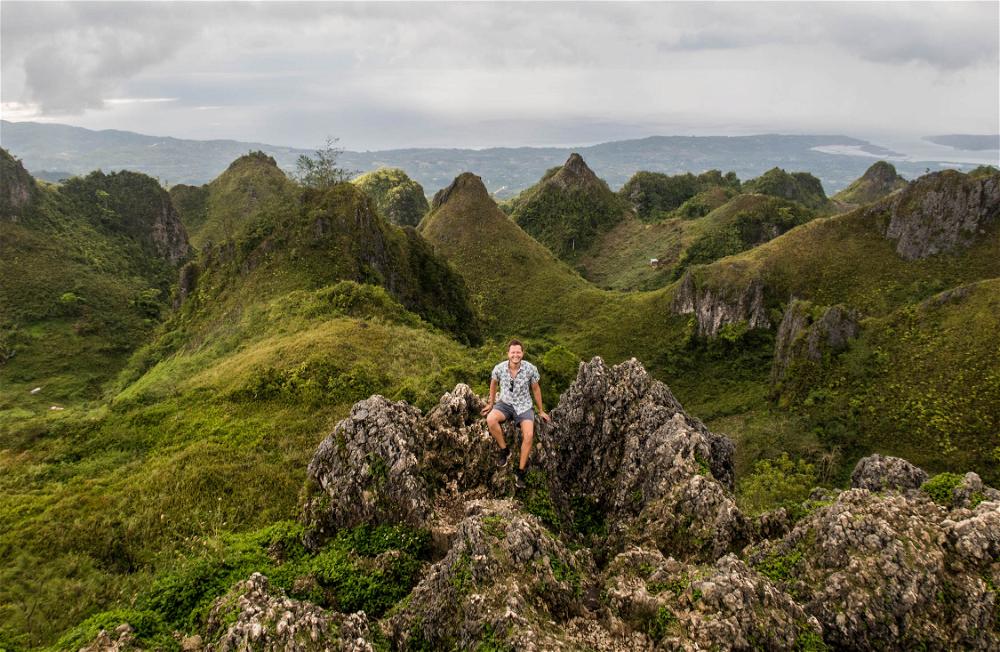 A man standing on top of a mountain in the philippines.