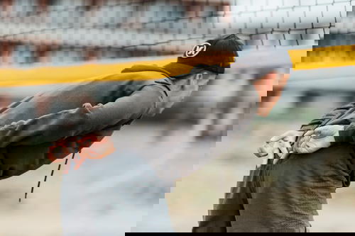 A man in a hat is bending over a volleyball net.