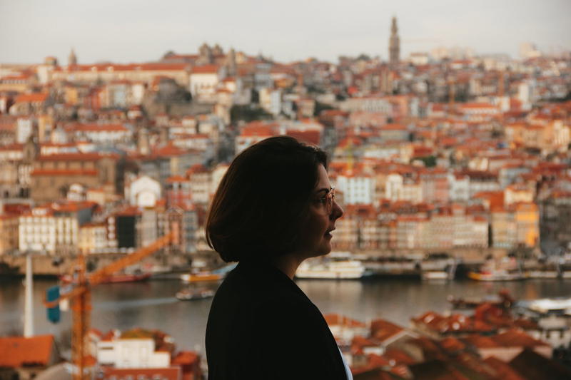 A silhouette of a woman looking out over the city of porto.