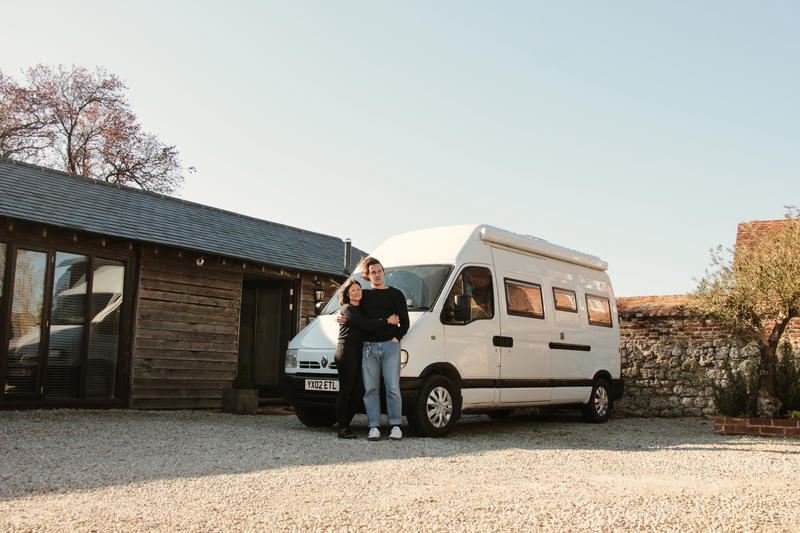 A man standing in front of a camper van.