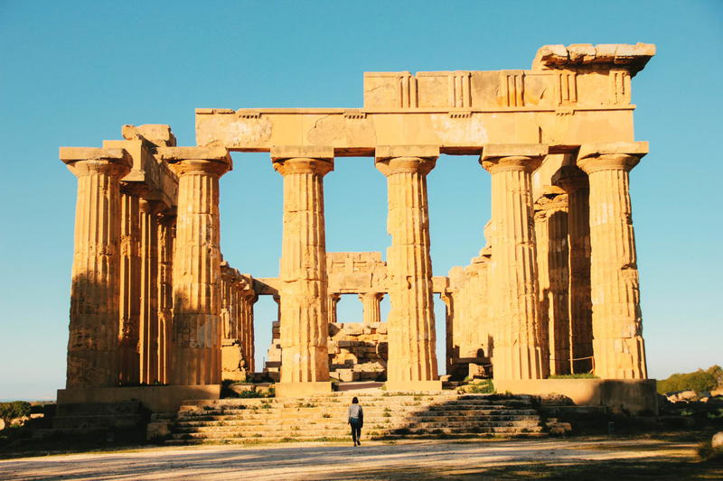 A person is standing in front of a temple.