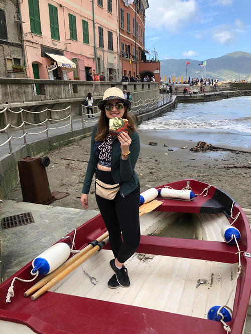 A woman in a hat is standing next to a boat.