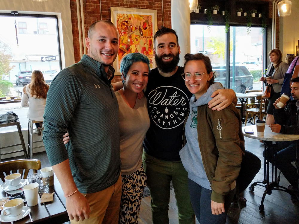 A group of people posing for a photo in a coffee shop.