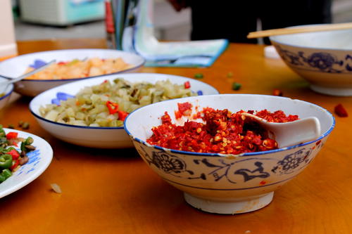 a wooden table topped with bowls of food