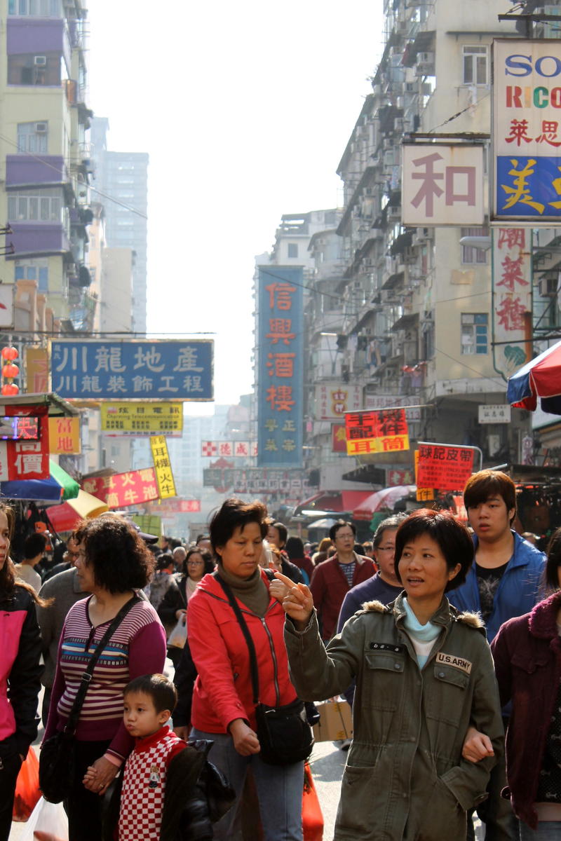 a crowd of people walking down a busy street