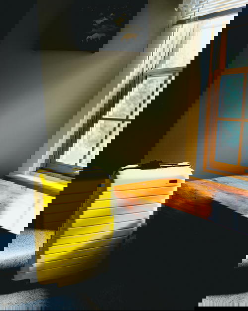 Yellow away suitcase in a room with sunlight