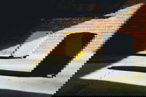 Away Luggage against ta brick wall in the sunlight
