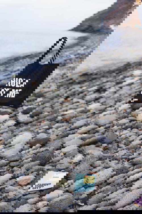 Fluent City tote bag hovering in the air at a rocky beach