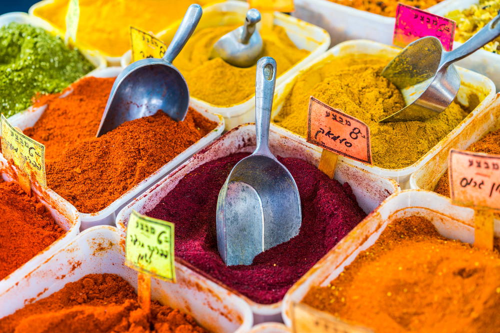 A variety of spices and spoons on a table.