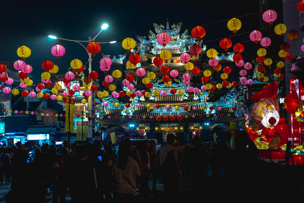 A group of people standing in a city at night.