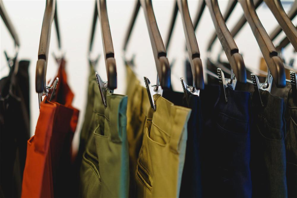 A row of colorful pants hanging on a rack.