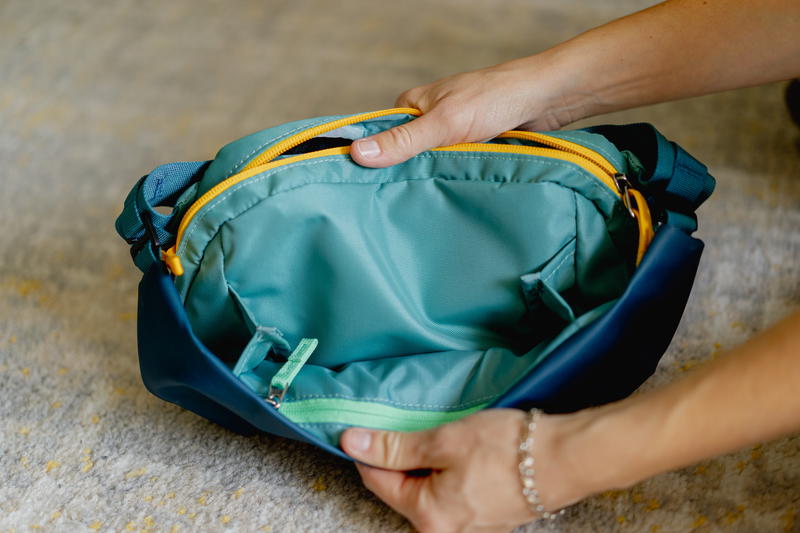 a person holding a blue and yellow bag
