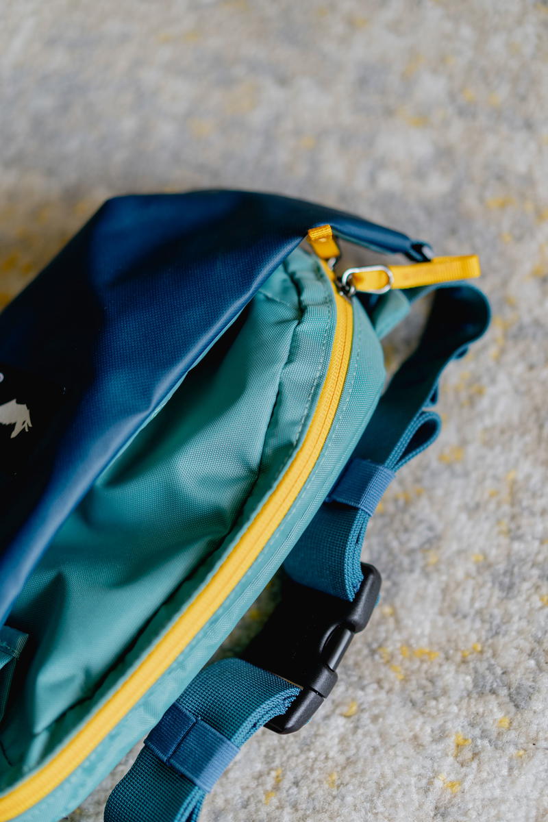 a blue and yellow bag sitting on the ground