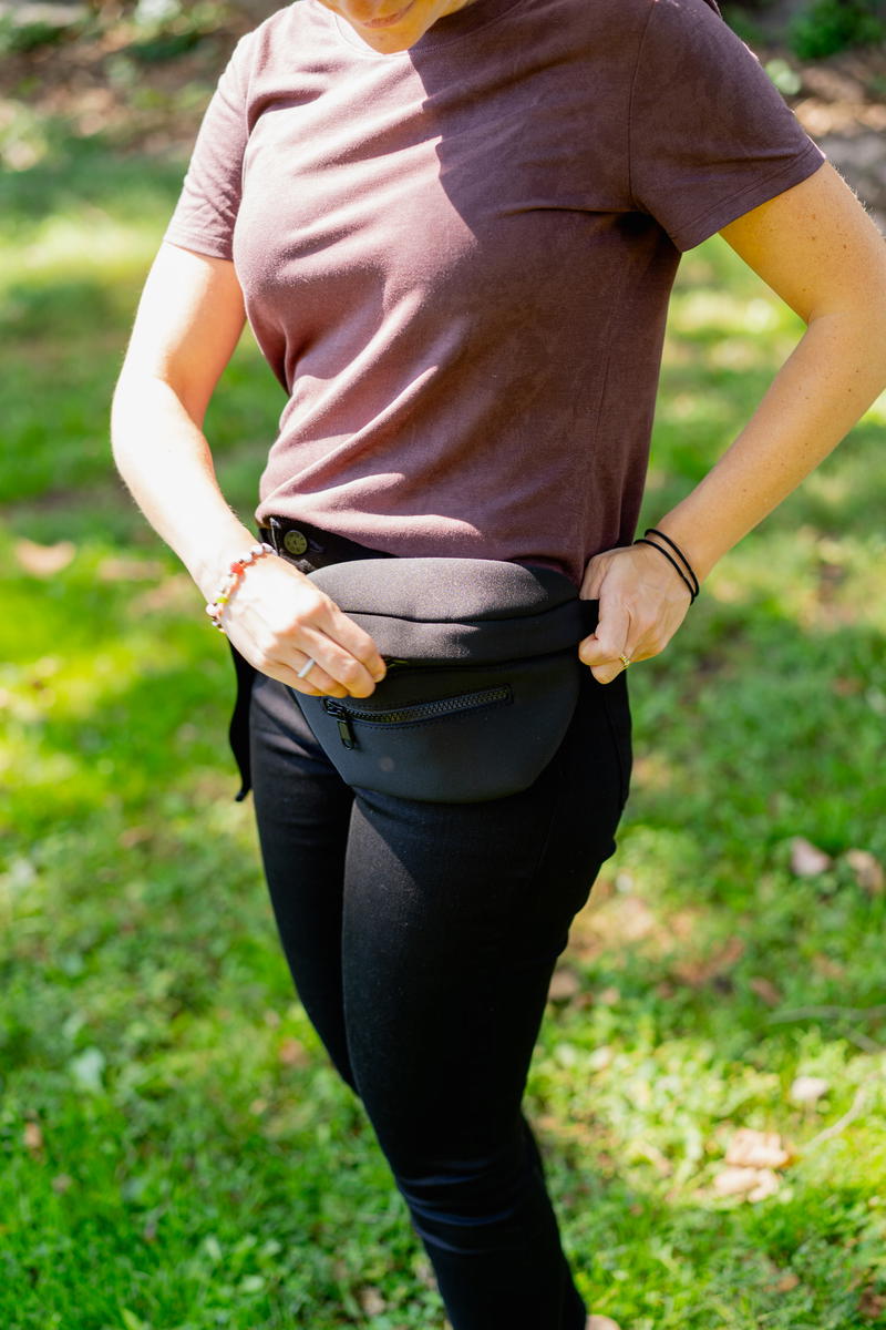 a woman standing in the grass with her hands on her hips