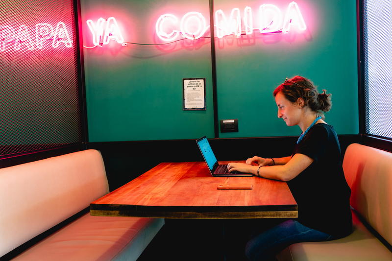 A woman sitting at a table with a laptop.