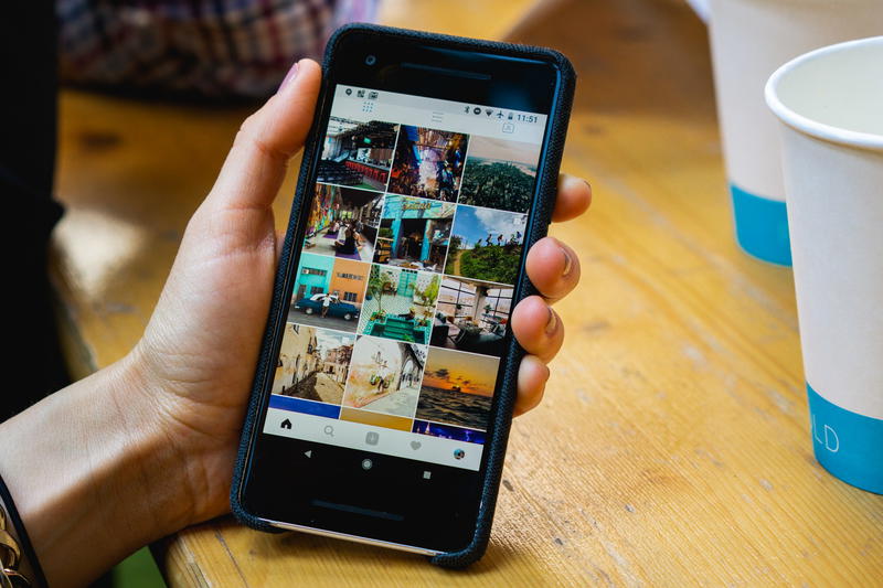 A person holding a smartphone with pictures on it.